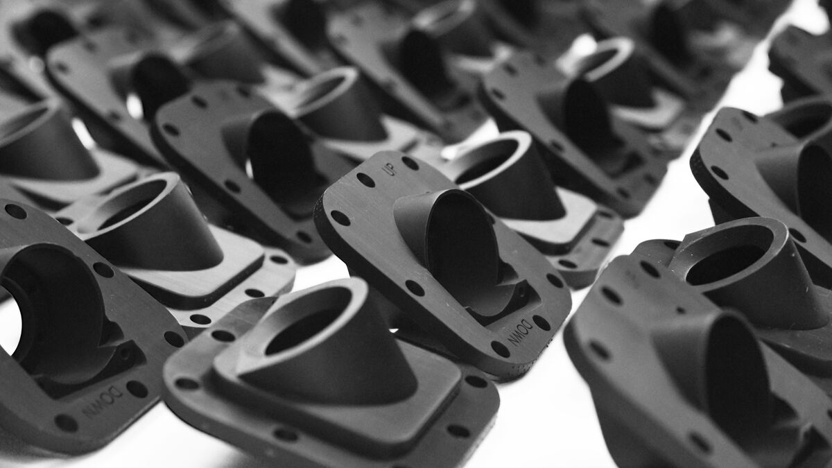 Batch of identical black camera housings 3D printed on a Stratasys Origin One