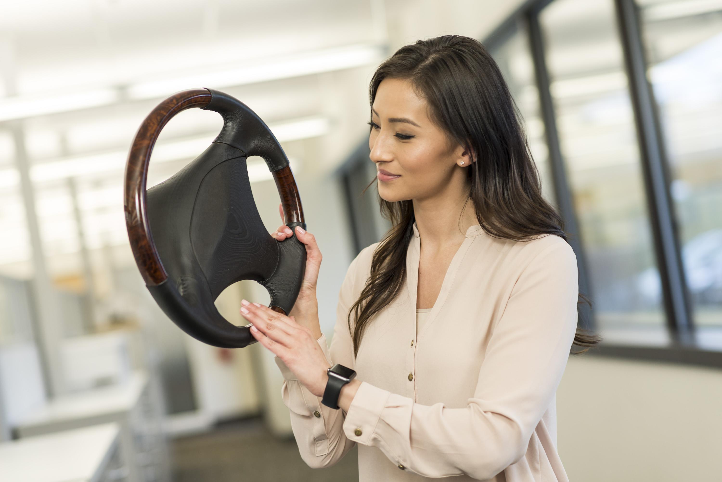 Designer holding a full-color 3D printed automotive steering wheel concept model