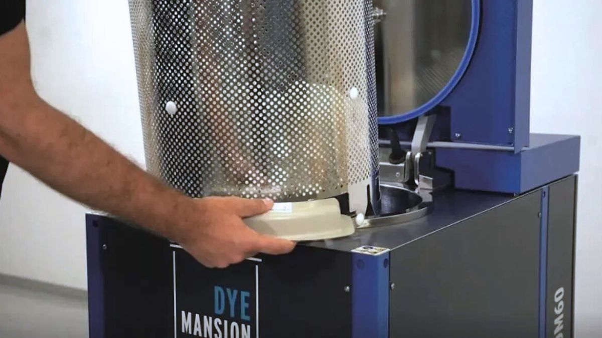 Operator loading a DyeMansion L-RR refresh cartridge into a DM60 dyeing system