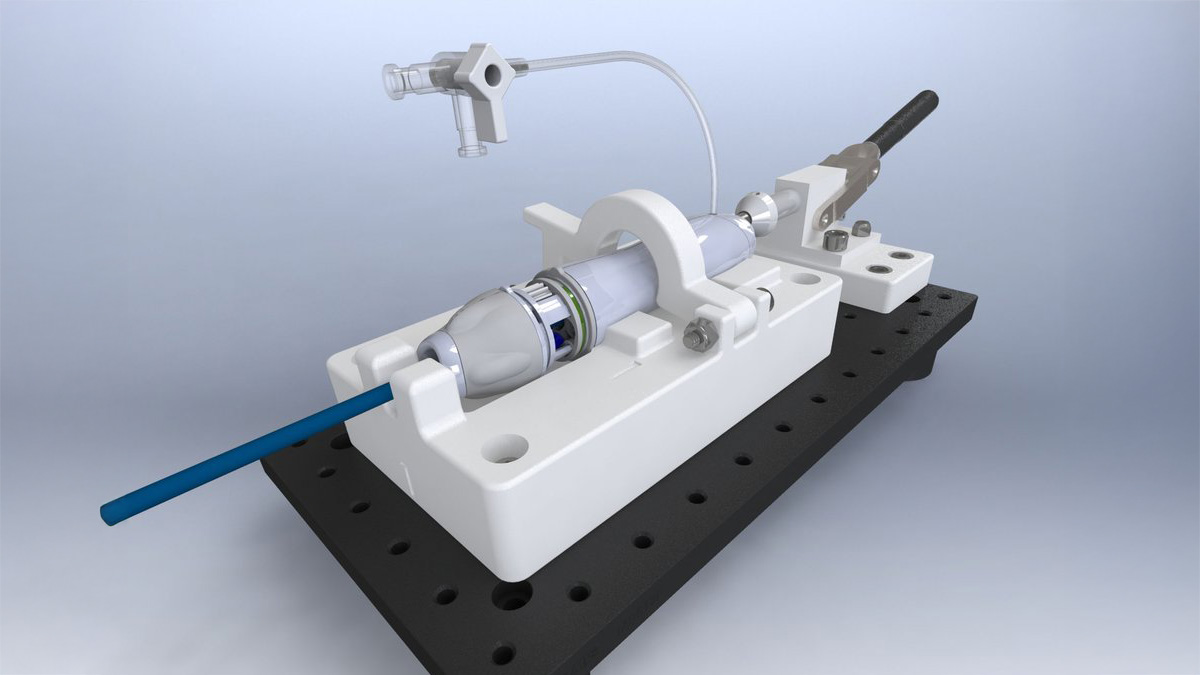 CNC-machined white fixture assembly with a precision drive shaft, designed by Interlink Engineering