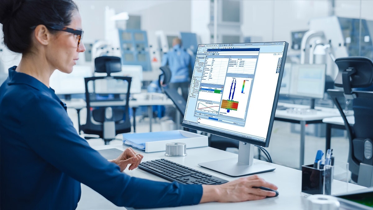 Engineer reviewing SOLIDWORKS Simulation results on a desktop monitor in a modern lab