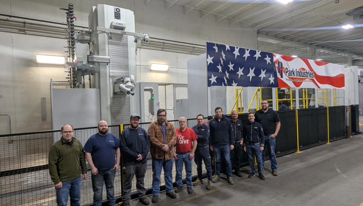 Park Industries machining team standing in front of a large portal mill and an American flag