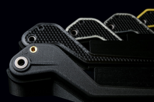 A part printed with Markforged that has different continuous fiber used, giving the handle new properties through the use of Kevlar, Fiberglass, and Carbon Fiber.