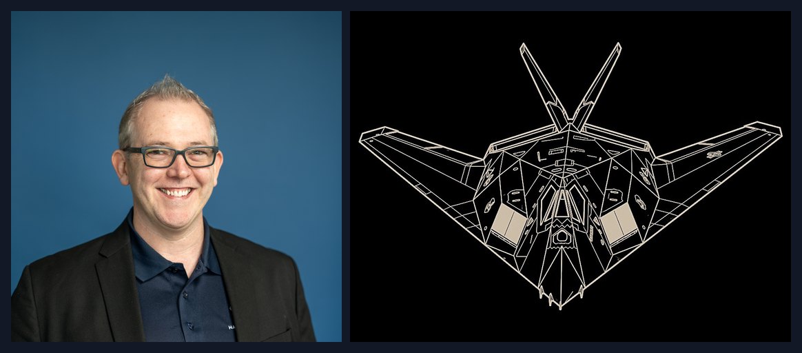 Scott Woods of Hawk Ridge Systems beside a white line drawing of the F-117 Nighthawk stealth aircraft, an example of engineering as art.