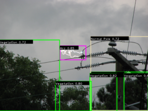 Real-time AI computer vision on power lines detecting electrical arc (pink box) and surrounding vegetation encroachment (green boxes) with confidence percentages.