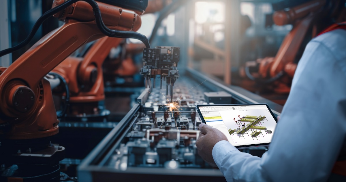 Engineers test the control of robot arm, Intelligent machine in factory industrial on real-time monitoring system software. Robots weld workpieces and produce industrial parts to reduce human labor