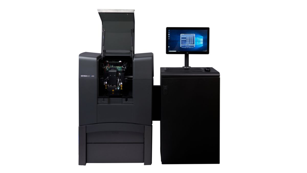 Stratasys J826 3D printer with front cover open, showing internal print area and connected workstation.