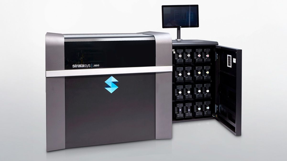 Stratasys J850 Pro 3D printer with material cabinet open, showing multiple print material cartridges.
