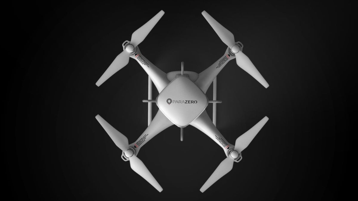 Top view of a white quadcopter drone with a Parazero module attached