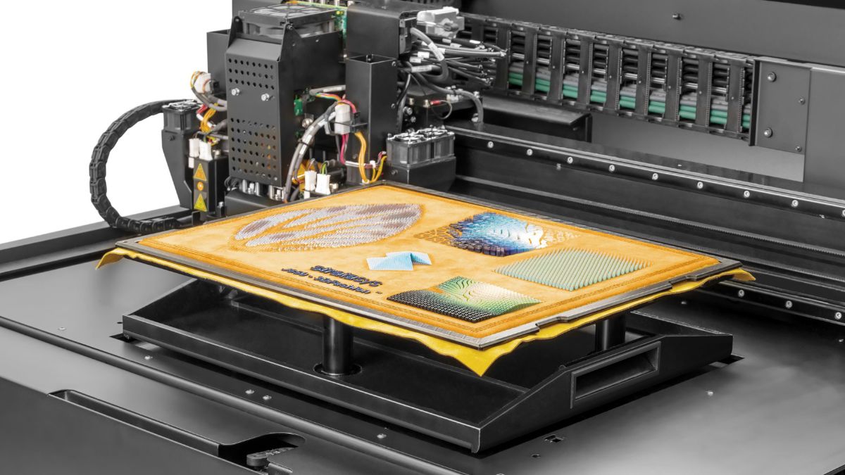 Close-up of a Stratasys J850 TechStyle 3D printer bed with textured samples on fabric.