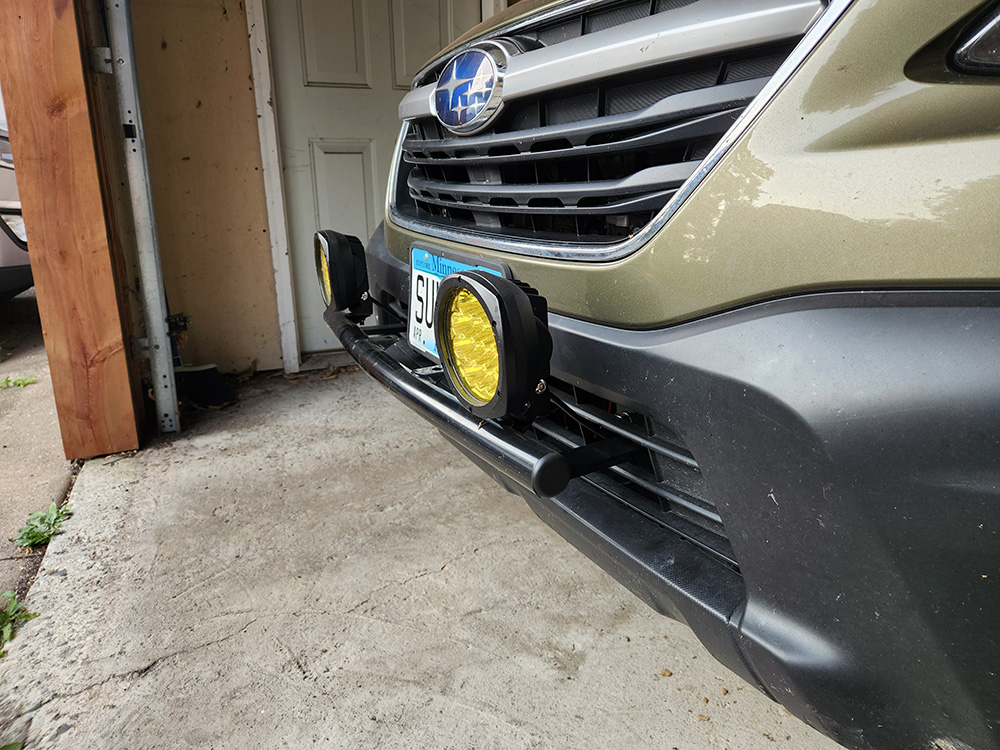 A front bumper of a Subaru Outback with mounted lights