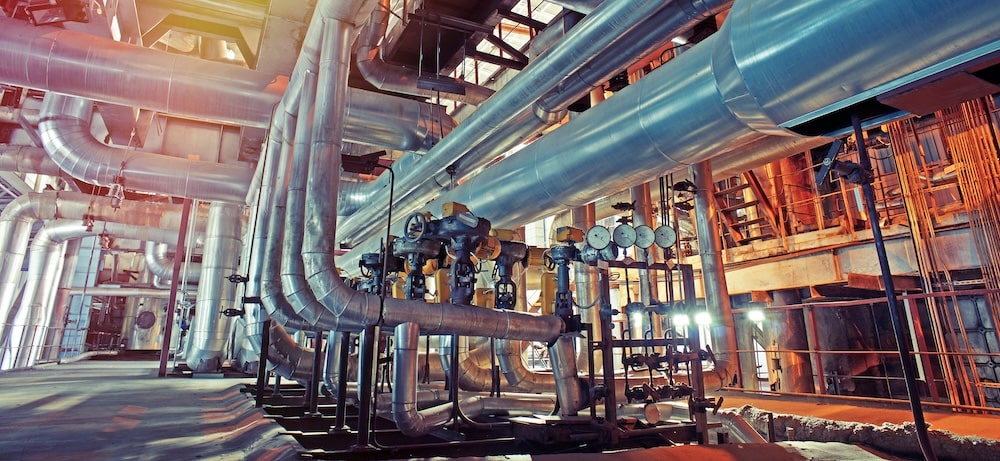 Industrial interior with large steel pipes and machinery in a manufacturing facility